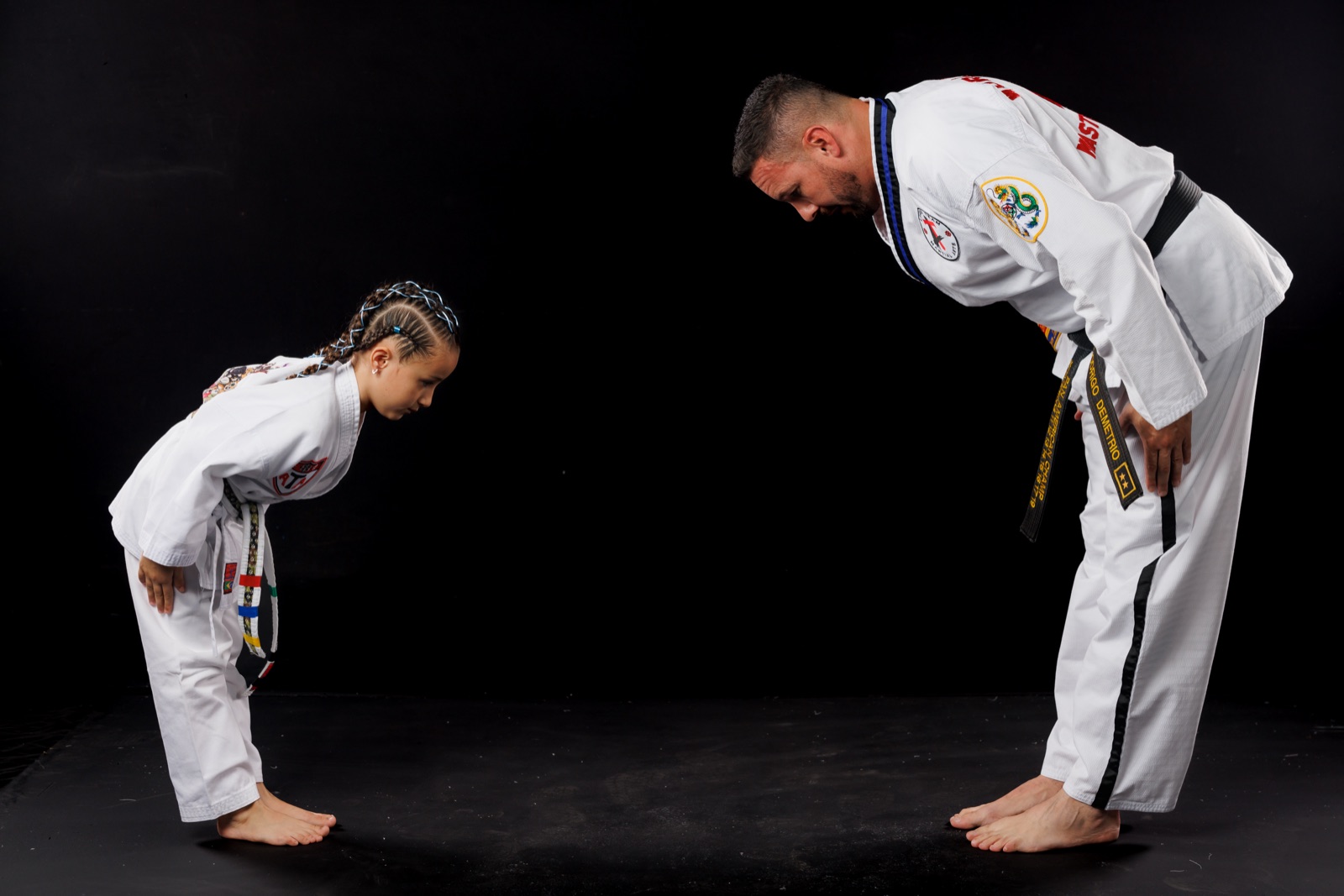 Aluna faz reverência ao mestre em um dojang da ATA LeaderTeam — respeito e tradição do Taekwondo Songahm em Curitiba
