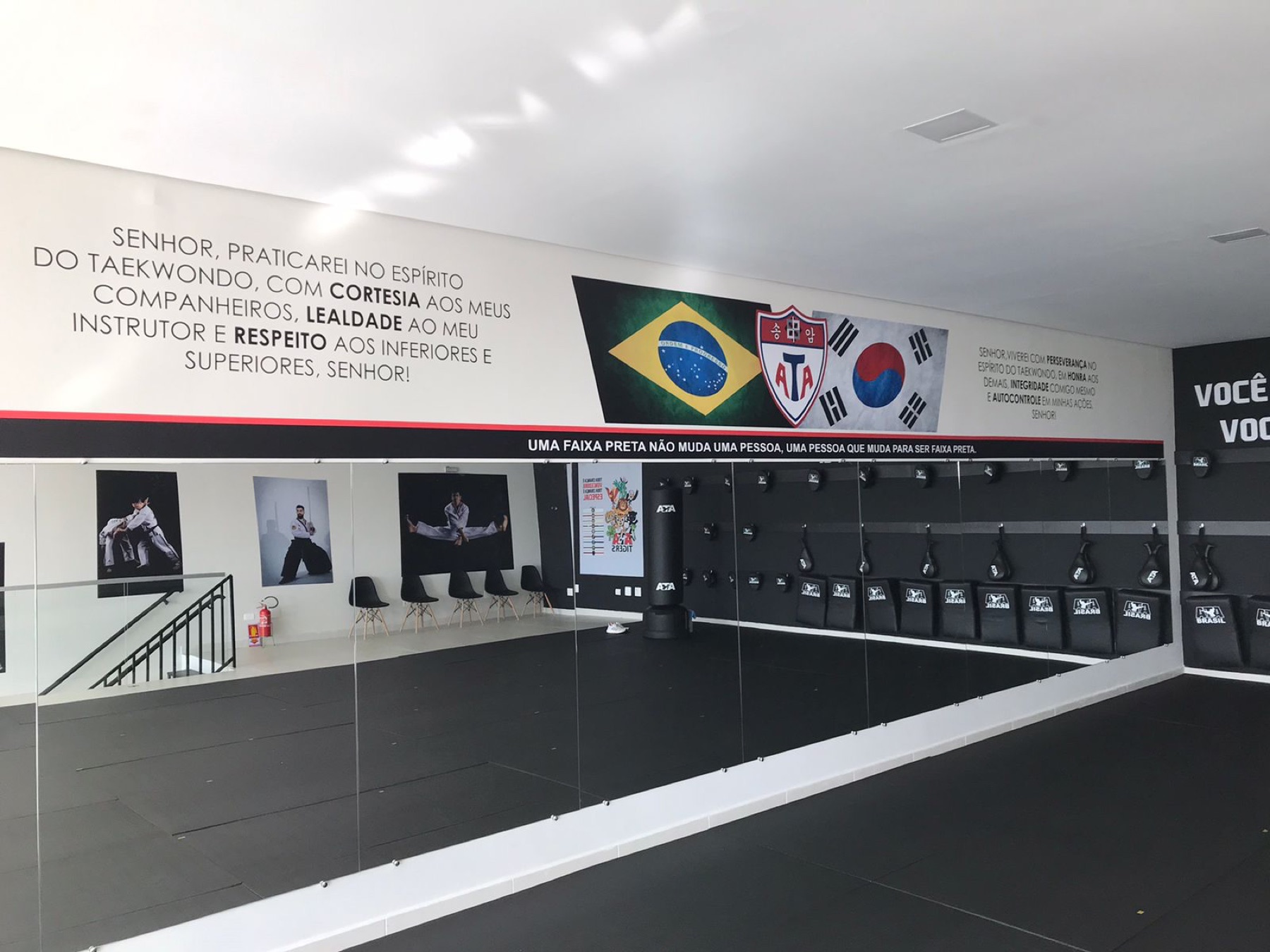 Parede do dojang com o juramento do aluno de Taekwondo, bandeiras do Brasil e da Coreia